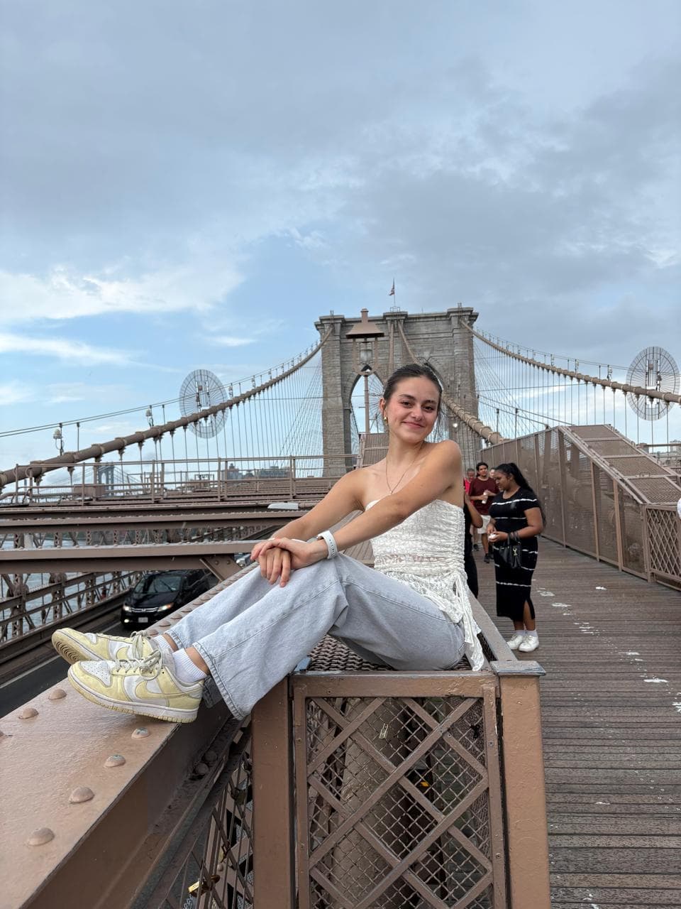 Valeria Mora sitting on the Brooklyn Bridge